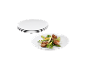 Trois assiettes blanches et une assiette avec de la viande et des légumes grillés.