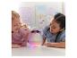 Deux filles regardent un jouet Hatchimals lumineux sur une table.