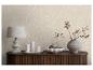 Un meuble en bois avec une lampe, des bougies et un vase décoratif devant un mur à motifs.