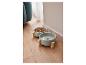 Deux gamelles grises pour chien sur un support en bois, remplies de nourriture et d'eau.
