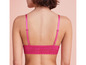 Une femme porte un soutien-gorge rose en dentelle.