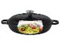 Cocotte en fonte noire avec couvercle, coupe transversale montrant des pâtes de courgettes, tomates et pignons.
