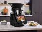 Robot culinaire Vorwerk Thermomix avec écran et accessoires vapeur.