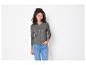 Une femme porte un pull gris et un jean bleu.