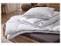 Couette et oreillers blancs avec liseré gris sur un lit à cadre en bois.