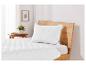 Un lit blanc avec une tête de lit en bois et une couette matelassée