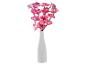 Orchidées roses illuminées dans un vase blanc.