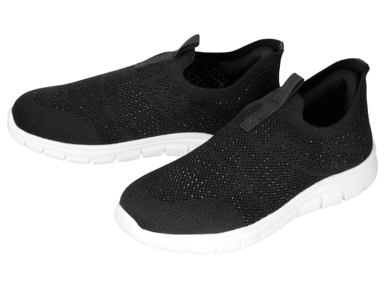 Une paire de chaussures de sport noires à enfiler avec une semelle blanche.