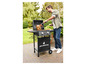 Un homme fait griller un poulet sur un barbecue à gaz Grillmeister.