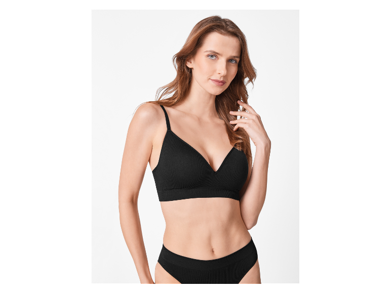 Modèle portant un soutien-gorge et une culotte noirs en dentelle.