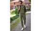 Un homme portant un sweat-shirt et un pantalon de survêtement verts avec des baskets blanches.