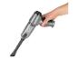 Aspirateur à main gris avec réservoir transparent et brosse.