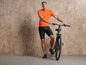 Un homme en tenue de cycliste avec un vélo noir