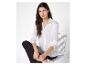 Une femme porte une chemise blanche et un pantalon noir.