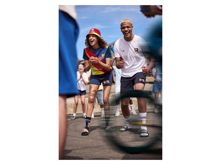 Deux personnes souriantes en tenue de sport colorée, avec un chapeau et des chaussettes assorties.