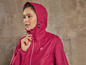 Une femme portant une veste imperméable rose à capuche