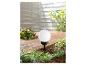 Lampadaire sphérique extérieur et plantes vertes.