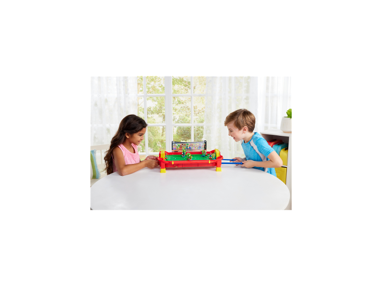 Deux enfants jouant à un jeu de football de table avec des figurines.