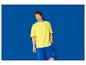 Homme en t-shirt jaune et short bleu avec le logo Lidl.
