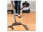 Une femme utilise un aspirateur Bissell MultiClean sur un sol en bois.