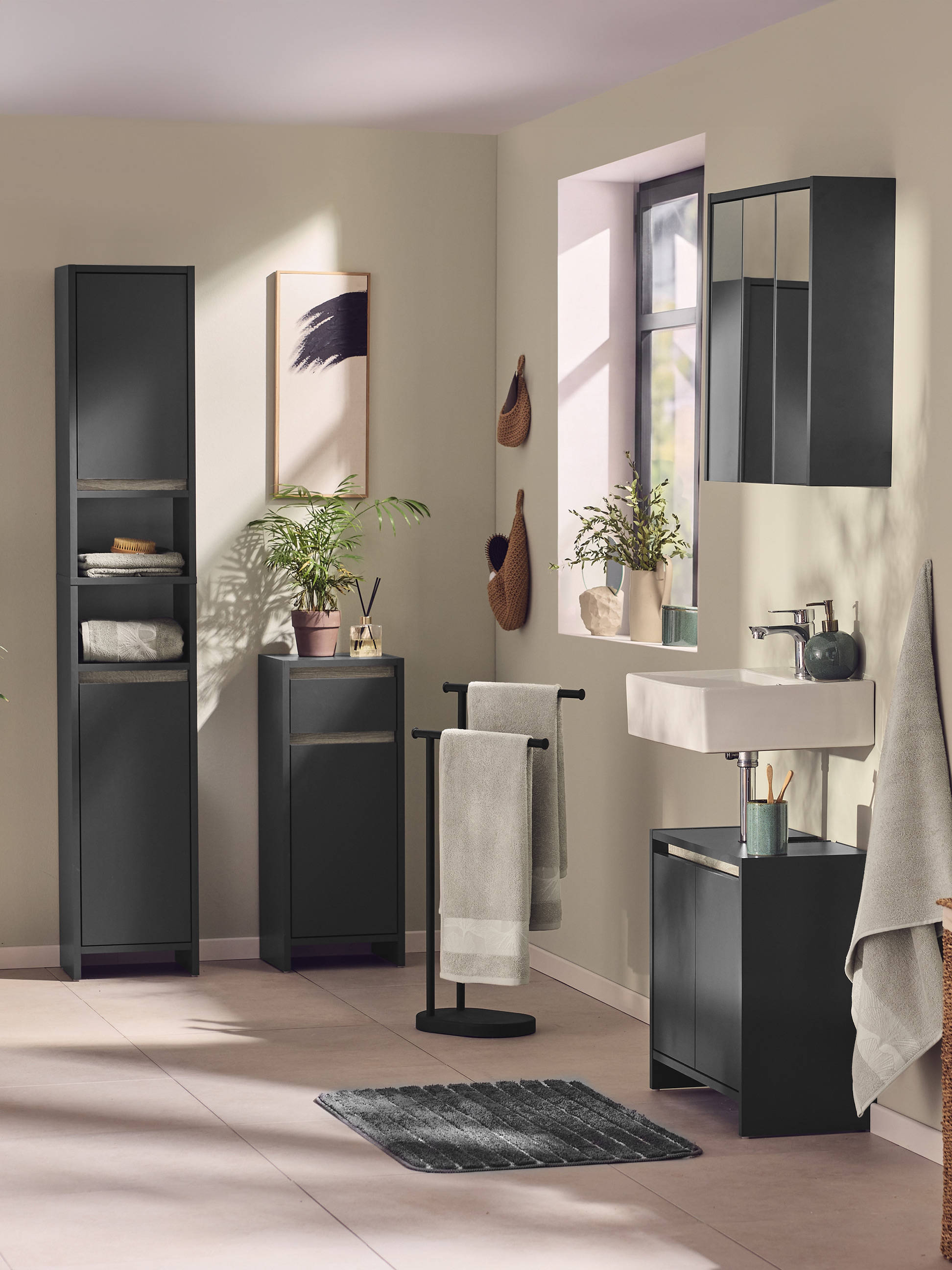 Salle de bain moderne avec des meubles de rangement gris foncé et des accessoires assortis.