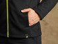 Un sweat-shirt noir avec une fermeture éclair jaune et une main dans la poche