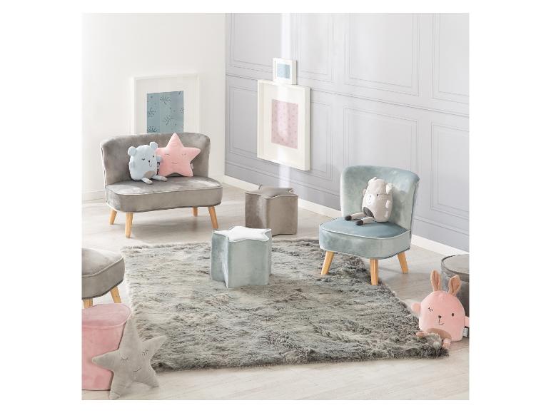 Chambre d'enfant avec petites chaises, poufs en forme d'étoile, tapis moelleux et coussins en peluche.