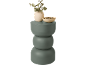 Vase décoratif vert en trois pièces avec des branches d'eucalyptus et un bol de galets.