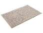 Tapis de bain beige texturé doux.
