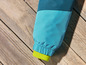 La manche bleue d'une veste avec une doublure verte sur un fond en bois.