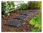 Dalles de pierre pour un chemin de jardin sur un lit de paillis.