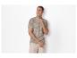 Polo à motif tropical et pantalon beige pour homme.