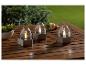 Trois lanternes en métal avec lumière de bougie LED sur une table en bois.