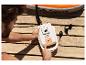 Homme gonfle une planche de SUP CRIVIT avec une pompe 20 V sur une terrasse en bois.