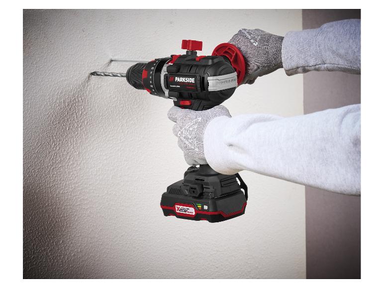 Personne perçant un mur avec une perceuse sans fil.