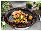 Grillades de saumon, crevettes et poulet sur une plancha en fonte sur un barbecue.