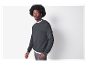 Modèle masculin portant un sweat-shirt gris foncé avec poche et pantalon gris.