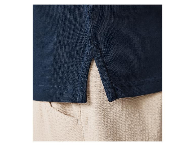 Polo bleu marine et pantalon beige clair.