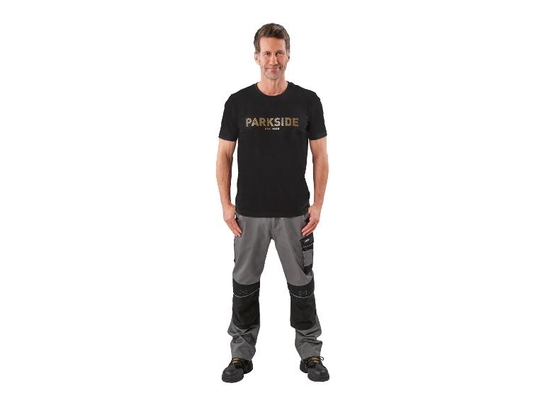 Homme en t-shirt noir avec texte et pantalon de travail gris