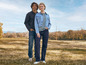 Un homme et une femme posent en jean et veste en jean à l'extérieur.