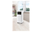 Un climatiseur mobile blanc avec un tuyau d'évacuation, placé près d'une fenêtre.