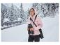Femme en veste softshell thermique rose CRIVIT avec jumelles dans un paysage enneigé.