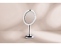 Miroir de maquillage rond avec éclairage LED et pied chromé.