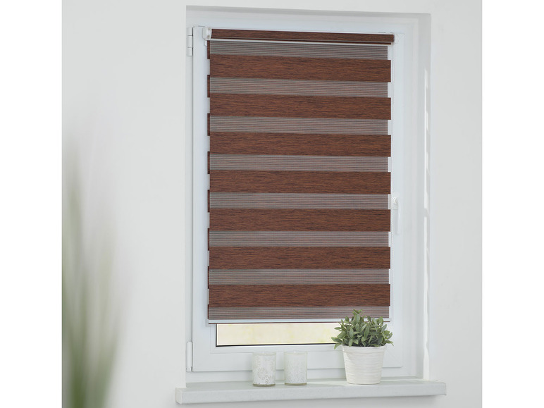 Un store enrouleur jour et nuit marron avec des rayures horizontales sur une fenêtre.