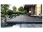 Terrasse moderne avec lames composites, piscine et transats dans un jardin.
