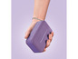 Un haut-parleur Bluetooth portable violet dans la main.