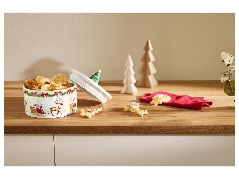 Boîte à biscuits de Noël avec biscuits assortis et décorations festives.