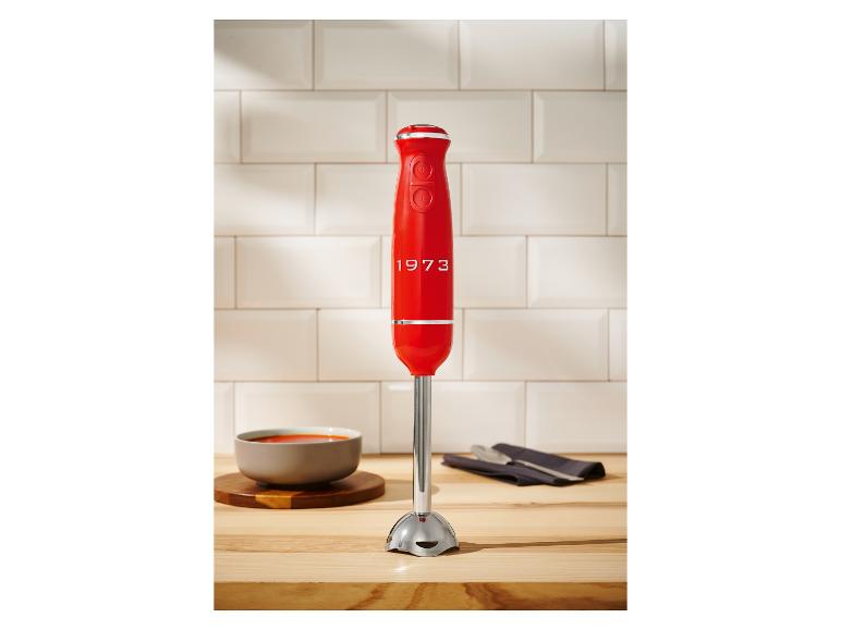 Un mixeur plongeant rouge 1973 KitchenAid sur un comptoir de cuisine.