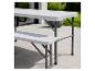 Table de pique-nique pliante grise avec bancs sur une terrasse.