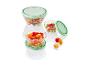 Bols en verre avec des couvercles verts remplis de salade, de poivrons et de tomates cerises.